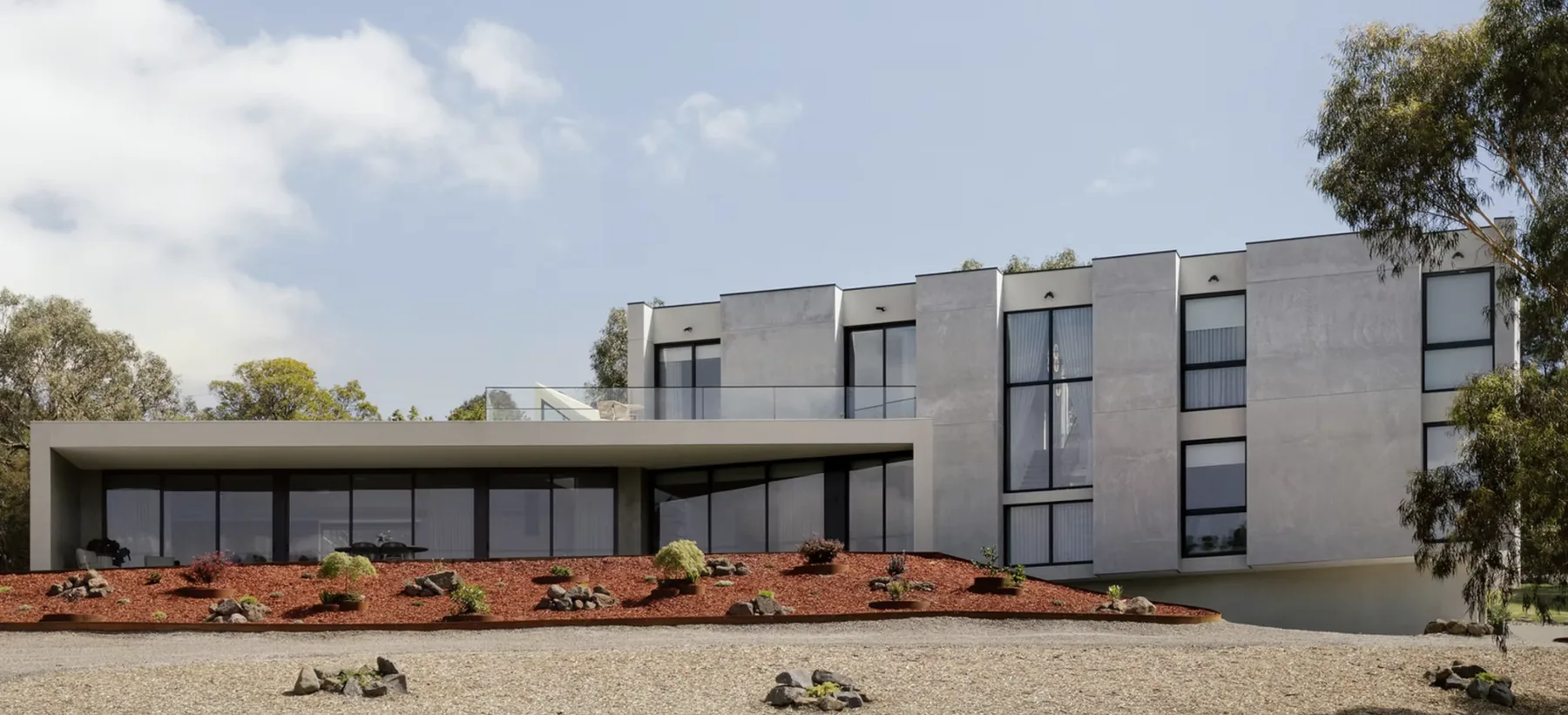 Brundrett View: A pavilion-style residence composed across a sloping landscape with long views and sheltered outdoor space.